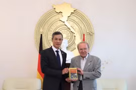 Nhà báo Hellmut Kapfenberger trao tặng Đại sứ Nguyễn Minh Vũ cuốn sách ''Tiểu sử chính trị Hồ Chí Minh'' mới xuất bản. (Ảnh: Thanh Bình/TTXVN)