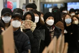 Người dân đeo khẩu trang phòng dịch COVID-19 khi xếp hàng bên ngoài một cửa hàng bán lẻ ở Daegu, Hàn Quốc. (Ảnh: AFP/TTXVN)