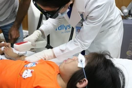 Các bác sỹ Bệnh viện Da liễu sử dụng liệu pháp triệt lông cho bé gái. (Ảnh: TTXVN phát)