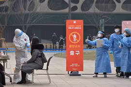 Nhân viên y tế lấy mẫu xét nghiệm COVID-19 cho người dân tại Seoul, Hàn Quốc ngày 23/12/2020. (Ảnh: AFP/TTXVN)