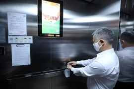 Dung dịch sát khuẩn luôn được để sẵn trong các thang máy tại các khu chung cư. (Ảnh: Phan Tuấn Anh/TTXVN)