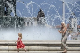 Người dân tránh nóng bên vòi phun nước tại Skopje, Bắc Macedonia. (Ảnh: AFP/TTXVN)