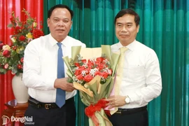 Quyền Chủ tịch Ủy ban Nhân dân tỉnh Võ Tấn Đức trao quyết định và tặng hoa chúc mừng Quyền Chủ tịch Ủy ban Nhân dân huyện Nhơn Trạch Nguyễn Thế Phong. (Nguồn: Báo Đồng Nai)