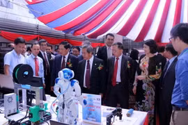 Lãnh đạo Bộ Khoa học và Công nghệ 2 nước Việt Nam-Lào và các đại biểu thăm các khu trưng bày và trình diễn công nghệ trong khuôn khổ Diễn đàn. (Ảnh: Phạm Kiên/Vietnam+)