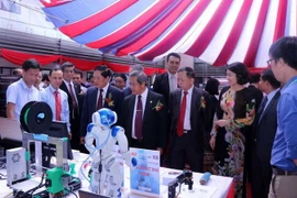 Lãnh đạo Bộ Khoa học và Công nghệ 2 nước Việt Nam-Lào và các đại biểu thăm các khu trưng bày và trình diễn công nghệ trong khuôn khổ Diễn đàn. (Ảnh: Phạm Kiên/Vietnam+)