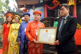 Đại diện Bộ Văn hóa, Thể thao, Du lịch trao bằng công nhận di sản văn hóa phi vật thể cấp quốc gia đối với Lễ hội Đền Hạ, Đền Thượng, Đền Ỷ La cho lãnh đạo thành phố Tuyên Quang. (Ảnh: Quang Cường/TTXVN)