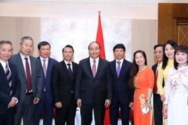 Thủ tướng Nguyễn Xuân Phúc, Chủ tịch Hội người Việt Nam tại Cộng hòa Séc Nguyễn Duy Nhiên (thứ tư từ trái sang), Chủ tịch Liên hiệp Hội người Việt Nam tại châu Âu Hoàng Đình Thắng (thứ ba từ trái sang) và các đại biểu chụp ảnh chung. (Ảnh: Thống Nhất/TTXV