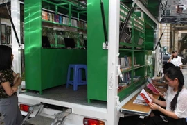 Các đại biểu tham quan không gian đọc của xe thư viện đa phương tiện lưu động. (Ảnh: Thanh Tùng/TTXVN)