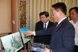 Chủ tịch UBND Thành phố Hồ Chí Minh Nguyễn Thành Phong và Tổng Giám đốc Điều hành Công ty Lotte Asset Development Lee Kwang Young trao đổi về phối cảnh dự án. (Ảnh: Tiến Lực/TTXVN)