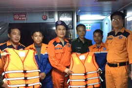 Lực lượng cứu nạn cùng hai ngư dân gặp nạn. (Ảnh: Trần Hoàng Ngọc/TTXVN)
