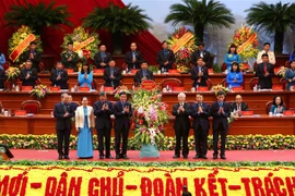  Tổng Bí thư Nguyễn Phú Trọng trao tặng lẵng hoa của Ban Chấp hành Trung ương Đảng chúc mừng đại hội. (Ảnh: Dương Giang/TTXVN)