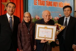Trao tặng Huy hiệu 70 năm tuổi Đảng cho đảng viên lão thành Lê Xuân Bá. (Ảnh: Hồng Kỳ/Vietnam+)