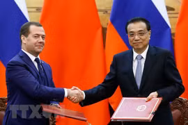 Thủ tướng Trung Quốc Lý Khắc Cường (phải) và Thủ tướng Nga Dmitry Medvedev (trái) tại lễ ký các thỏa thuận hợp tác song phương ở Bắc Kinh, Trung Quốc ngày 7/11/018. (Ảnh: AFP/TTXVN)