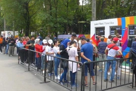 Người dân xếp hàng dài chờ mua vé. (Ảnh: Đỗ Quyên/Vietnam+)