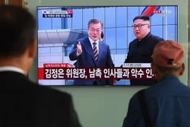 Người dân Hàn Quốc theo dõi hình ảnh truyền hình trực tiếp Nhà lãnh đạo Triều Tiên Kim Jong-un (phải, phía xa) đón Tổng thống Hàn Quốc Moon Jae-in (trái, phía xa) tại sân bay quốc tế Bình Nhưỡng ngày 18/9/2018. (Ảnh: AFP/ TTXVN)