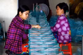 Người dân làng lưới Thơm Rơm tất bật sản xuất hàng phục vụ nhu cầu đánh bắt thủy sản trong mùa lũ. (Ảnh: Thanh Liêm/TTXVN)