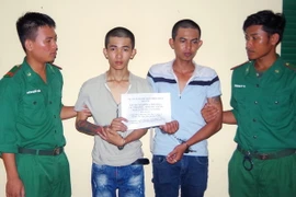 Hai đối tượng Vương Quốc Nghĩa và Trần Như Ý tại cơ quan điều tra. (Ảnh: Trung Hiếu/TTXVN)