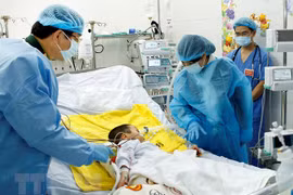 Bộ trưởng Bộ Y tế Nguyễn Thị Kim Tiến thăm bệnh nhi Ly Chương Bình, 7 tuổi được ghép phổi. (Ảnh: Dương Ngọc/TTXVN)