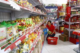 Khách hàng lựa chọn mua lương thực tại cửa hàng tiện ích. (Ảnh: Đình Huệ/TTXVN)