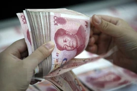 Đồng 10000 Yên Nhật (phía trên) và đồng 100 Nhân dân tệ của Trung Quốc (phía dưới) tại ngân hàng ở Hoài Bắc, tỉnh An Huy, Trung Quốc. (Ảnh: AFP/TTXVN)