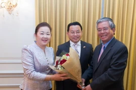 Đại sứ Phạm Quang Vinh (phải) tặng hoa chúc mừng Đại sứ Mai Sayavongs và phu nhân. (Ảnh: Đoan Hùng/Vietnam+)