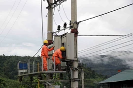 Cán bộ nhân viên kỹ thuật của công ty điện Nậm Nhùn (Mường Tè) kiểm tra, khắc phục sự cố hệ thống lưới điện bị thiệt hại do mưa lũ gây ra tại Trung tâm xã Mường Tè. (Ảnh: Quý Trung/TTXVN)