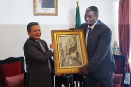 Bộ trưởng Du lịch và Nghề thủ công Algeria Abdelkader Benmessaoud trao bức tranh lưu niệm tặng Đại sứ Việt Nam tại Algeria Phạm Quốc Trụ . (Ảnh: Tấn Đạt/TTXVN)