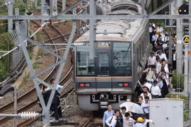 Hành khách sơ tán khỏi tàu hỏa sau trận động đất tại Osaka, Nhật Bản ngày 18/6. (Nguồn: AFP/TTXVN)