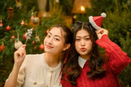 Hai nàng hậu hóa "bà già Noel" trao quà cho các bệnh nhi tự kỷ. (Ảnh: CTV/Vietnam+)