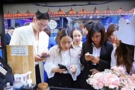 Du khách mua tour khuyến mại trong Ngày hội "Tết xưa, Tết nay" của Vietravel. (Ảnh: CTV/Vietnam+)