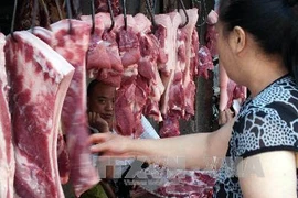 Khách hàng chọn mua thịt lợn tại khu chợ ở Yichang, tỉnh Hồ Bắc, Trung Quốc. (Nguồn: AFP/TTXVN)