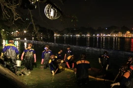 Công việc được tiến hành khẩn trương dù thực hiện trong đêm tối. (Ảnh: Nhật Anh/TTXVN)