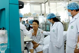 Bộ trưởng Bộ Y tế Nguyễn Thị Kim Tiến đến thăm, tặng quà động viên các bệnh nhân được chuyển về điều trị tại Bệnh viện Bạch Mai. (Ảnh: Dương Ngọc/TTXVN)