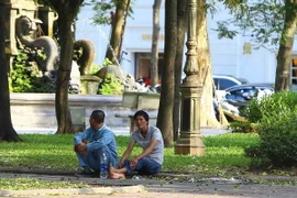Nhiều người tìm những bóng mát trong công viên để tránh nắng. (Ảnh: Minh Quyết/TTXVN)