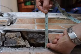 Một nền nhà của người dân đường Nguyễn Văn Trỗi bị trồi sụt, nứt gãy. (Ảnh: Nguyễn Dũng/TTXVN)
