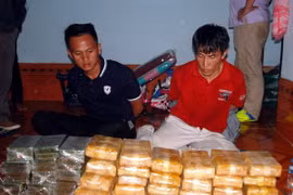 Hai đối tượng bị lực lượng chức năng bắt giữ cùng tang vật. (Ảnh: Hùng Dũng/TTXVN)