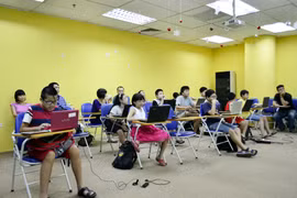 Những em nhỏ mê lập trình nhờ sự kèm cặp bởi những thầy cô giáo "không chuyên" của FPT. (Ảnh: H.T/Vietnam+)