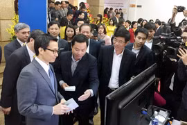 Nhân viên bưu điện trình bày về dịch vụ mới với Phó Thủ tướng Vũ Đức Đam. (Ảnh: T.H/Vietnam+)