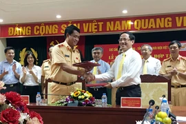 Lãnh đạo Cục Cảnh sát giao thông và VietnamPost ký kết thỏa thuận, giúp người vi phạm đơn giản hóa quy trình nộp phạt vi phạm giao thông. (Ảnh: T.H/Vietnam+)