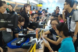 Nhiều khách hàng đã "tạm quên" cơn bão số 3 để đến trải nghiệm và mua Galaxy Note 7. (Ảnh: T.H/Vietnam+)