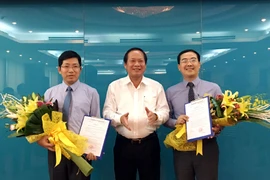 Bộ trưởng Trương Minh Tuấn trao quyết định cho ông Lưu Đình Phúc (trái) và ông Đinh Tiến Dũng (phải). (Ảnh: CTV/Vietnam+)