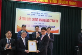 Chủ tịch UBND tỉnh Bắc Ninh trao giấy chứng nhận đầu tư 100 triệu USD cho đại diện Công ty Hanwha Techwin Security Hàn Quốc. (Ảnh: Thái Hùng/TTXVN)