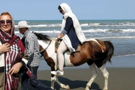Khách du lịch dạo chơi trên bãi biển ở thành phố cảng Gisum, Iran. (Nguồn: AFP/TTXVN)