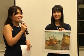 Ban Tổ chức bán đấu giá tranh để gây quỹ. (Ảnh: Xuân Vịnh/Vietnam+)