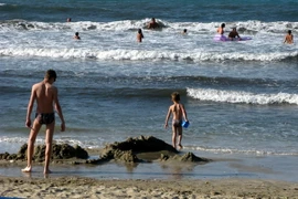 Người dân Hy Lạp làm giảm bớt cái nóng tại một bãi biển ở ngoại ô thủ đô Athens. (Nguồn: THX/TTXVN)