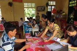 Người dân thôn Vịnh Mốc, xã Vĩnh Thạch, huyện Vinh Linh, tỉnh Quảng Trị làm thủ tục nhận tiền đền bù sự cố môi trường biển. (Ảnh Trần Tĩnh/TTXVN)