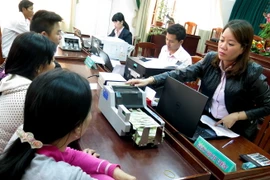 Nhân viên Phòng giao dịch Ngân hàng Chính sách Xã hội huyện Tuy Phước, Bình Định, đang làm thủ tục cho hộ nghèo vay vốn. (Ảnh: Viết Ý/TTXVN)