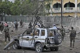 Binh sỹ Somali đứng gần đống đổ nát sau vụ tấn công bằng bom xe nhắm vào một trạm kiểm soát ở Mogadishu ngày 21/3. (Nguồn: AP)