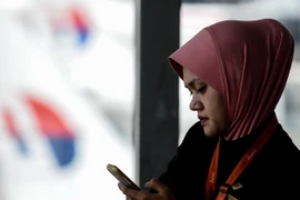 Người dân Malaysia sử dụng điện thoại di động tại Sepang. (Nguồn: AFP/TTXVN)