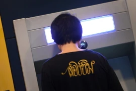 Khách hàng sử dụng máy rút tiền tự động ATM của ngân hàng Commonwealth ở Sydney, Australia ngày 3/8. (Nguồn: AFP/TTXVN)